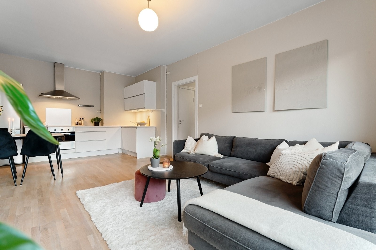 Boligen har et stilrent kjøkken som ligger i en åpen, sosial løsning mot stuen Galleribilde