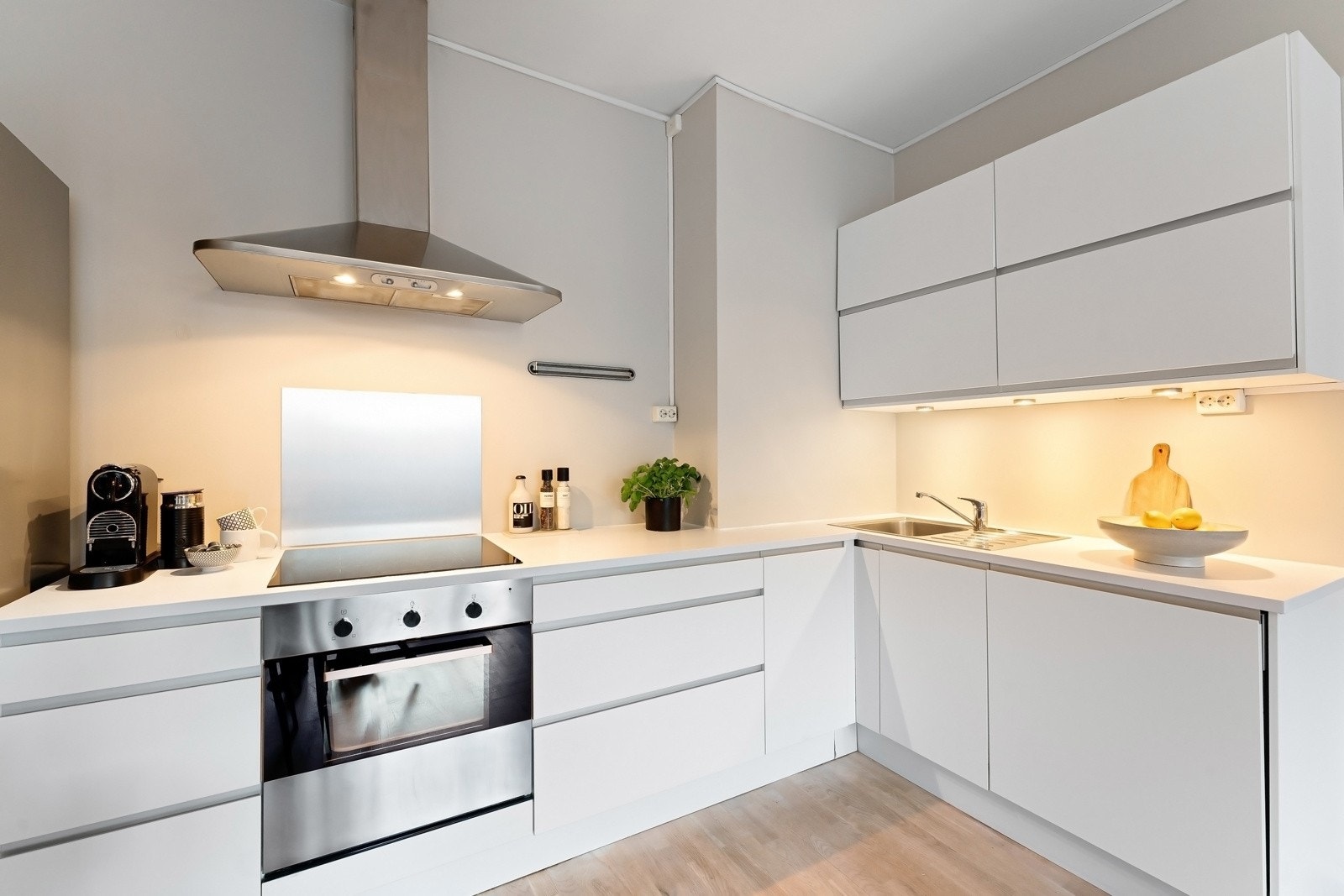 Innredningen inkluderer integrerte hvitevarer som oppvaskmaskin, samt frittstående kjøleskap. Plateslått backsplash og ventilator med kullfilter Galleribilde