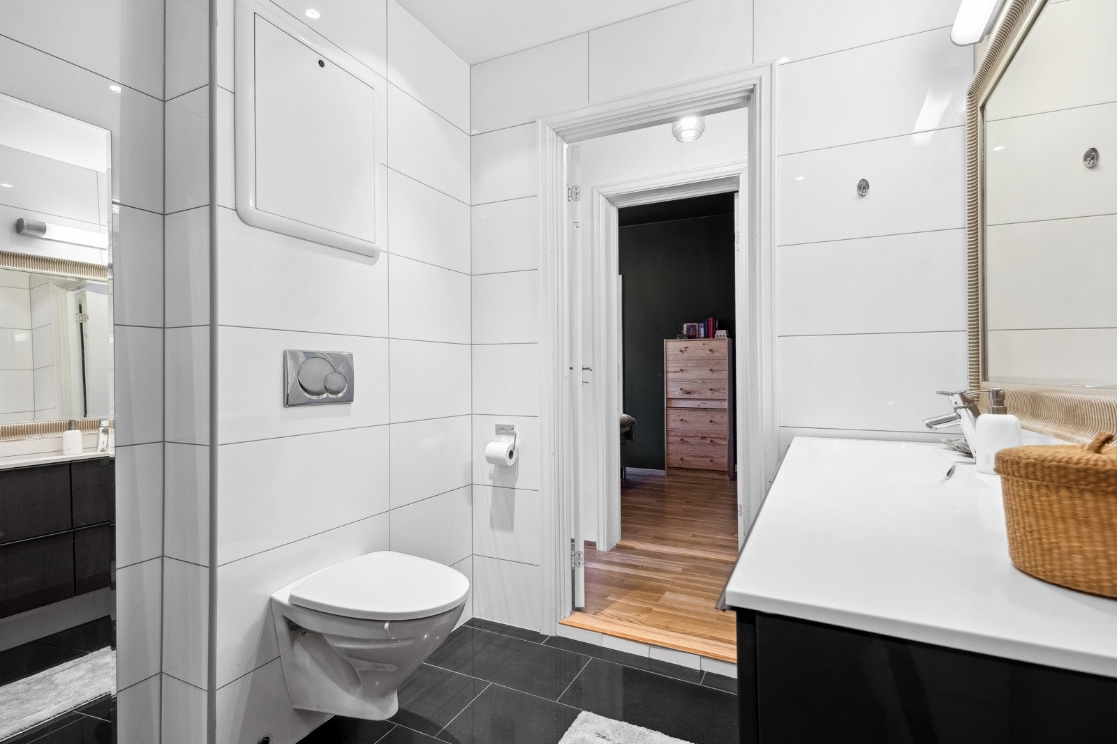 Badet er utstyrt med vegghengt toalett, servantinnredning og dusjhjørne i glass. Galleribilde