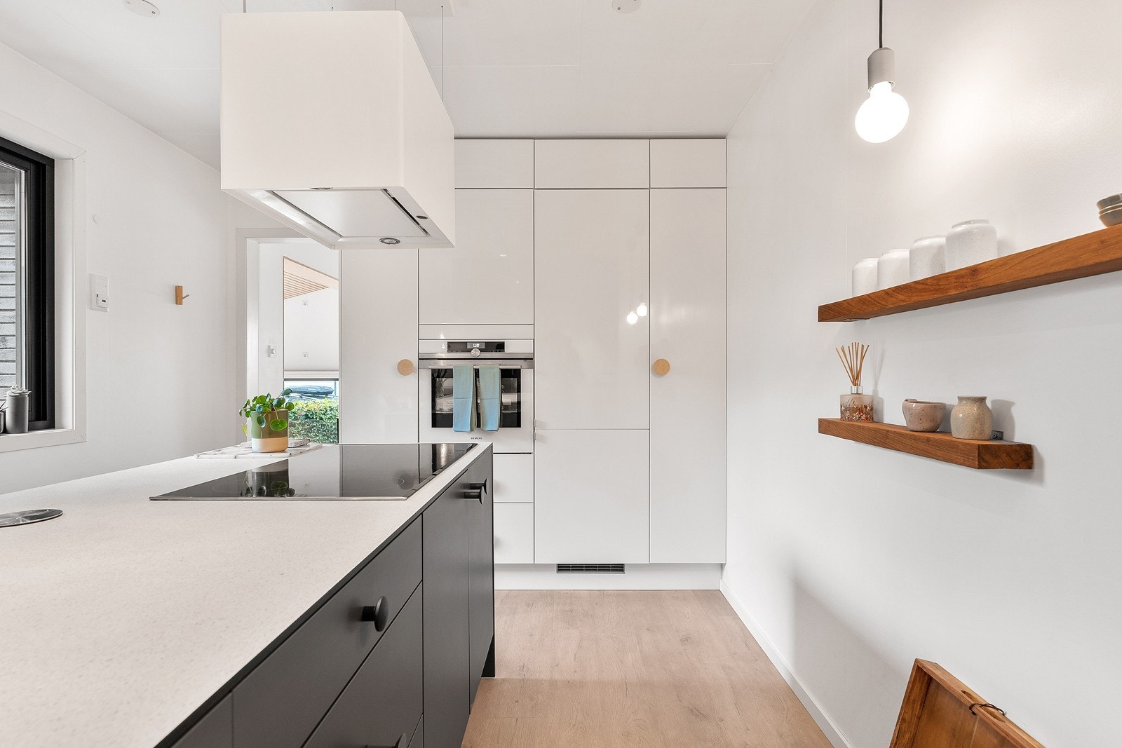 Kjøkkenet er innredet med slette fronter, kompositt benkeplate og integrerte hvitevarer. Galleribilde