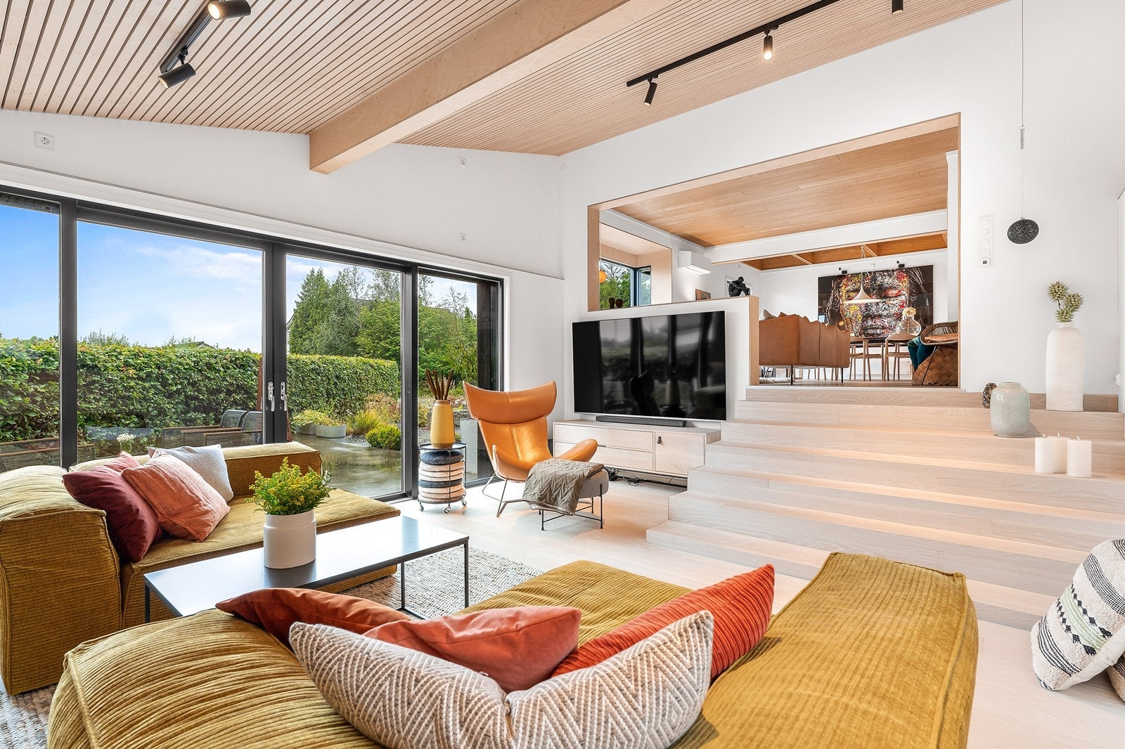 Moderne stue med parkett i gulv og store skyvedører i glass som gir godt med lysinnslipp. Galleribilde