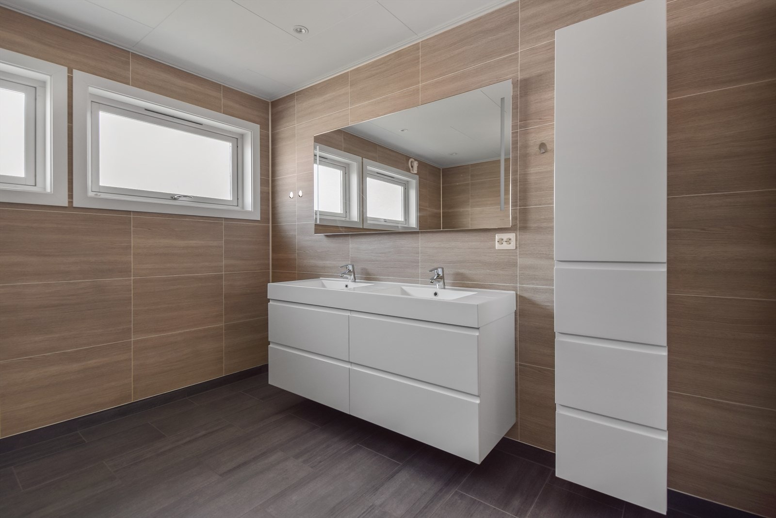 Bad er av særdeles god størrelse tilpasset for flere brukere og har i tillegg avdelt dusjrom. Baderomsinnredning i slett utførelse og dobbel servant Galleribilde