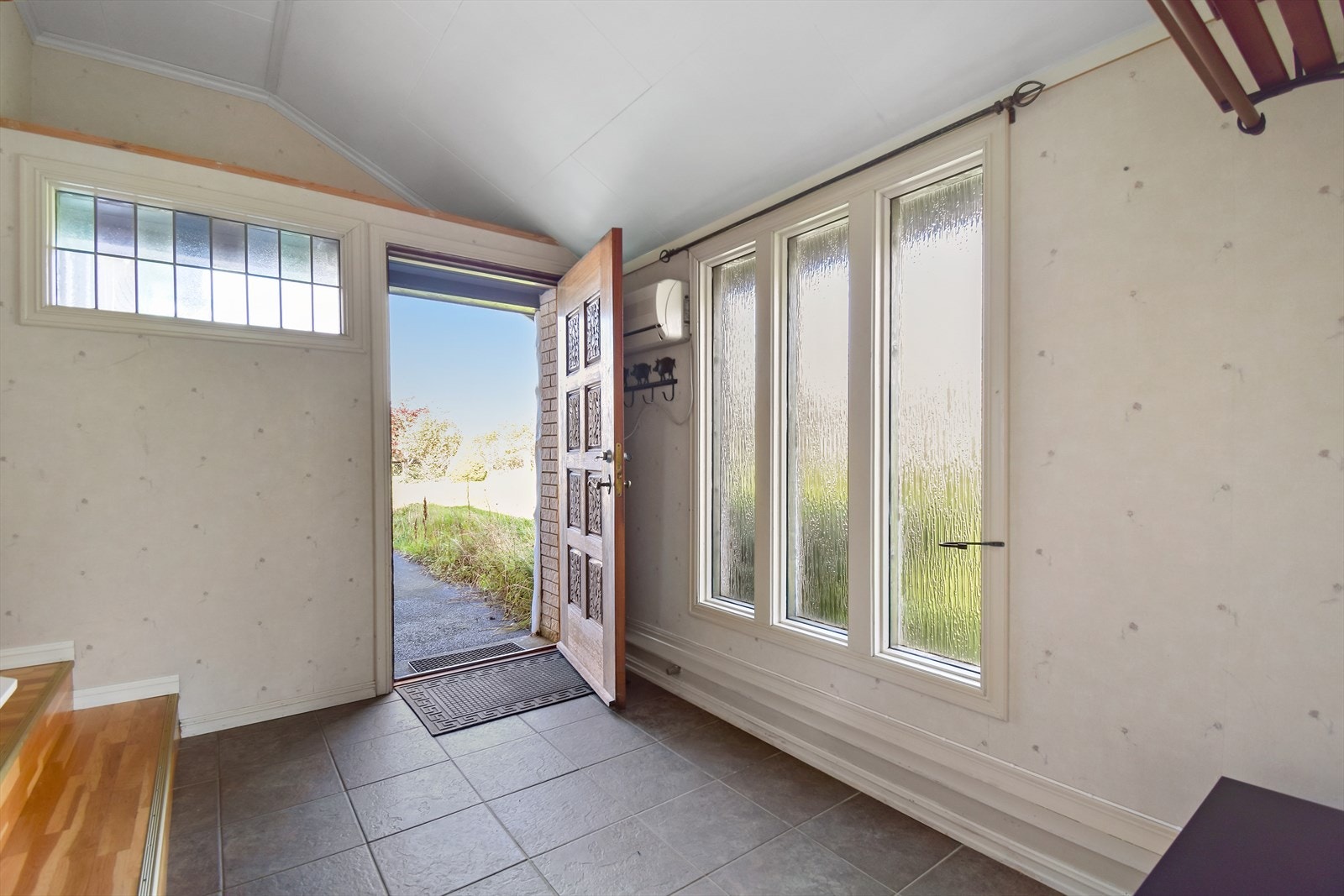 1.etg.: Flislagt og romslig entre med vinduer som lyser opp gangen. Her er det også veggplass til knagger for oppheng av yttertøy. Galleribilde