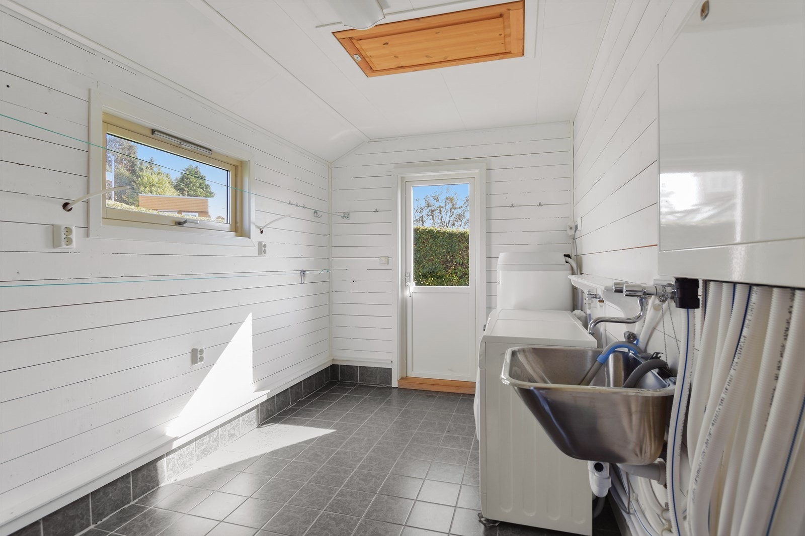 Vaskerommet er utstyrt med flislagt gulv med varmekabler. Med god veggplass er det plass til praktisk innredningsløsning for en barnefamilie. Galleribilde