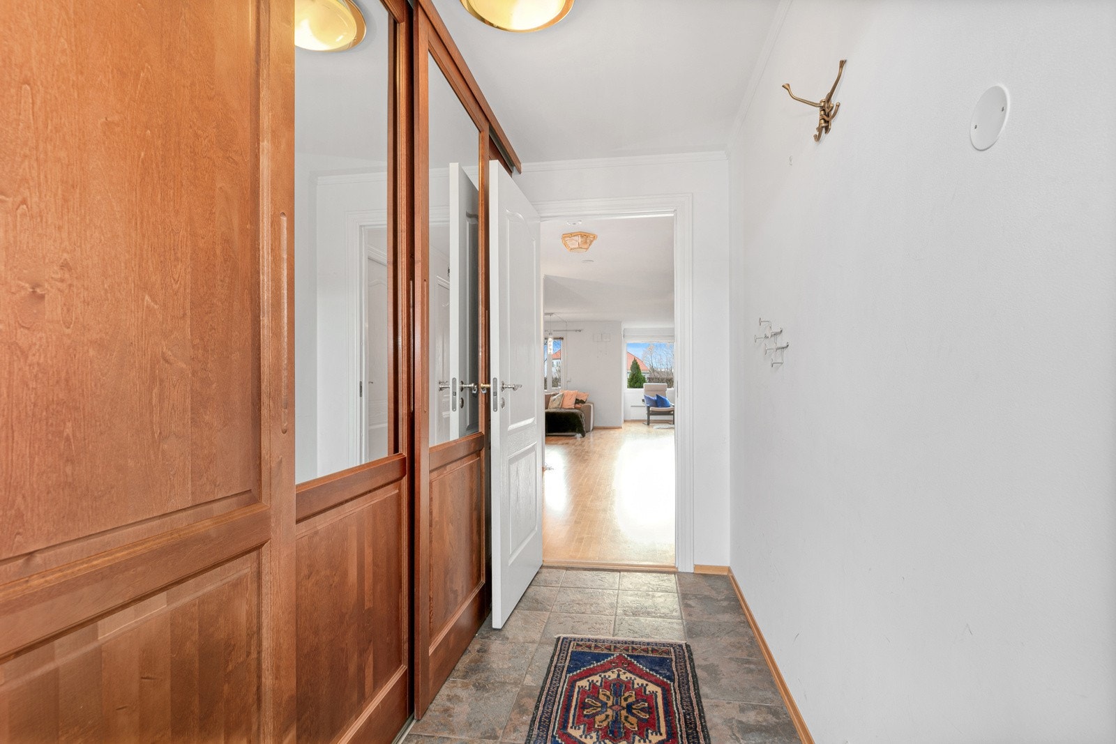 Entré med garderobe og flislagt gulv med varmekabler Galleribilde