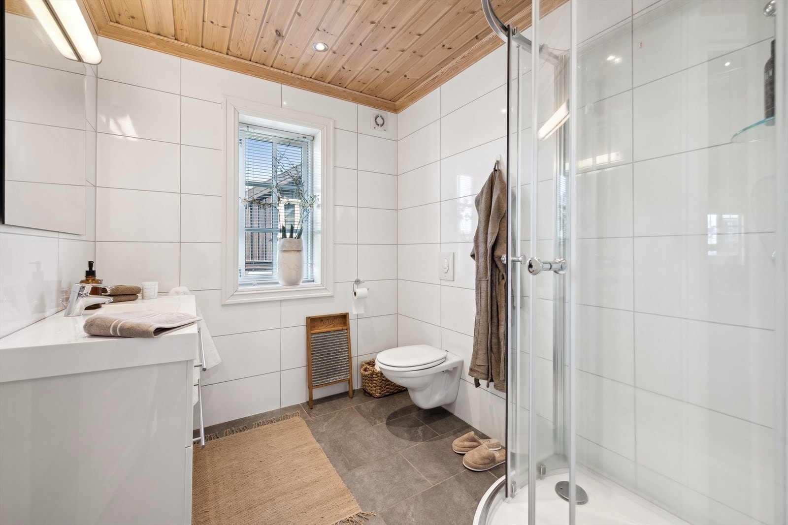 Hytta har to pene bad, et i hver etasje. På veggene er det hvite fliser og på gulvet er det brune fliser. Det er gulvvarme, vegghengt toalett og dusjkabinett. Det er wifi styring på varmekabler. Galleribilde