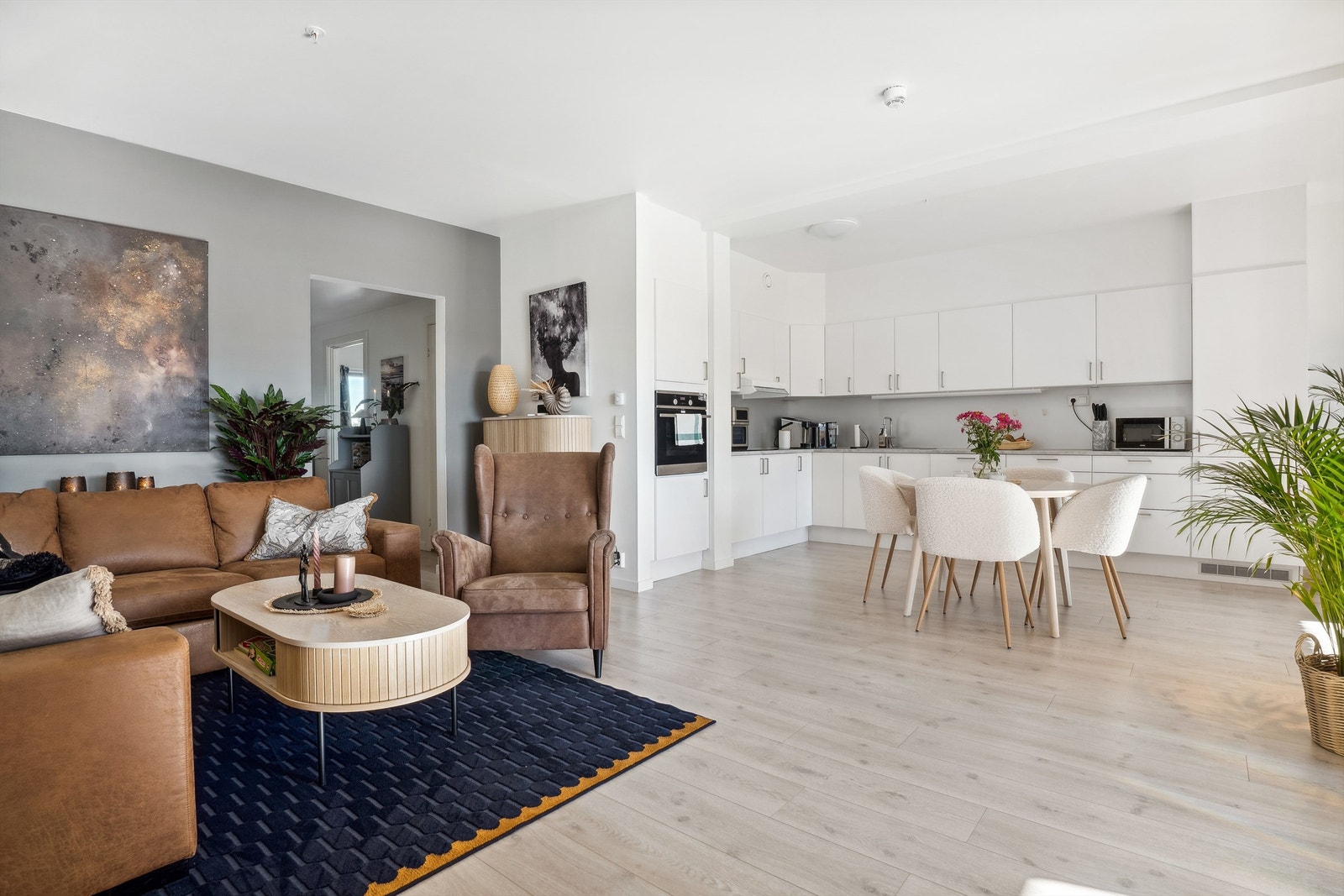 Lyst og lekkert kjøkken med lys og stilren innredning med integrerte hvitevarer. Galleribilde