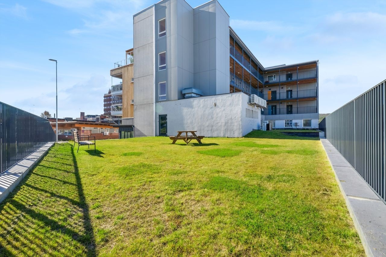 Fellesarealet er solrikt, og pent opparbeidet med plen og sittebenker. Galleribilde