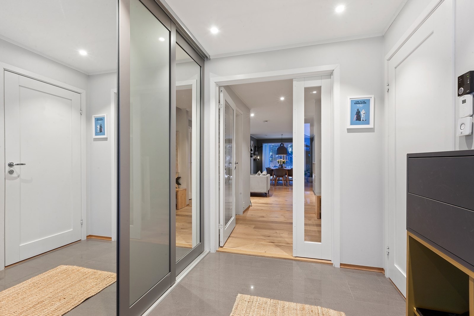 Velkommen inn! Lys entré med praktisk innebygget skyvedørsgarderobe Galleribilde