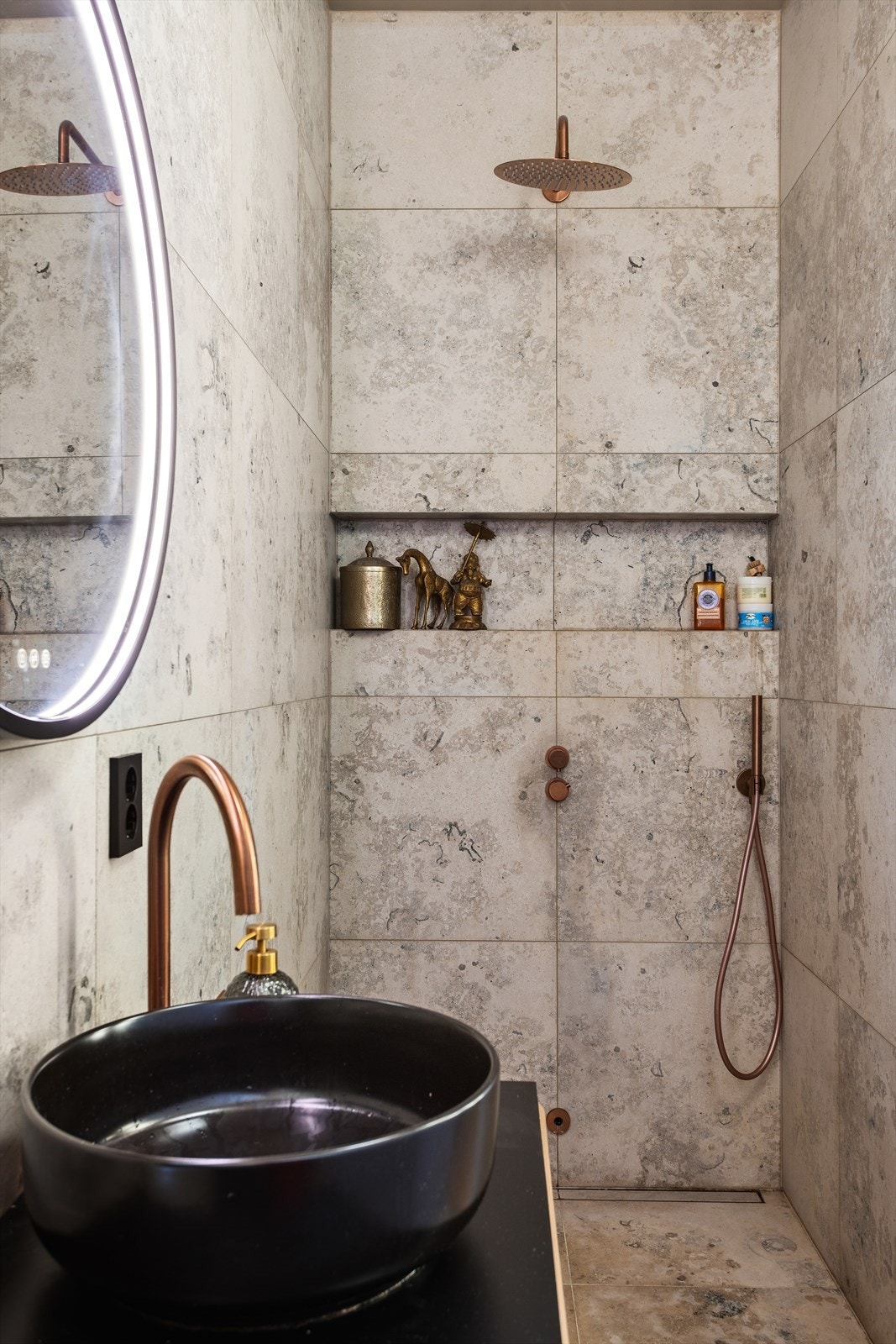 Badet er utstyrt med benkeskap med profilerte fronter, speil og belysning over servant, dusj på gulv, servant og veggfestet klosett med innebygget sisterne. Galleribilde