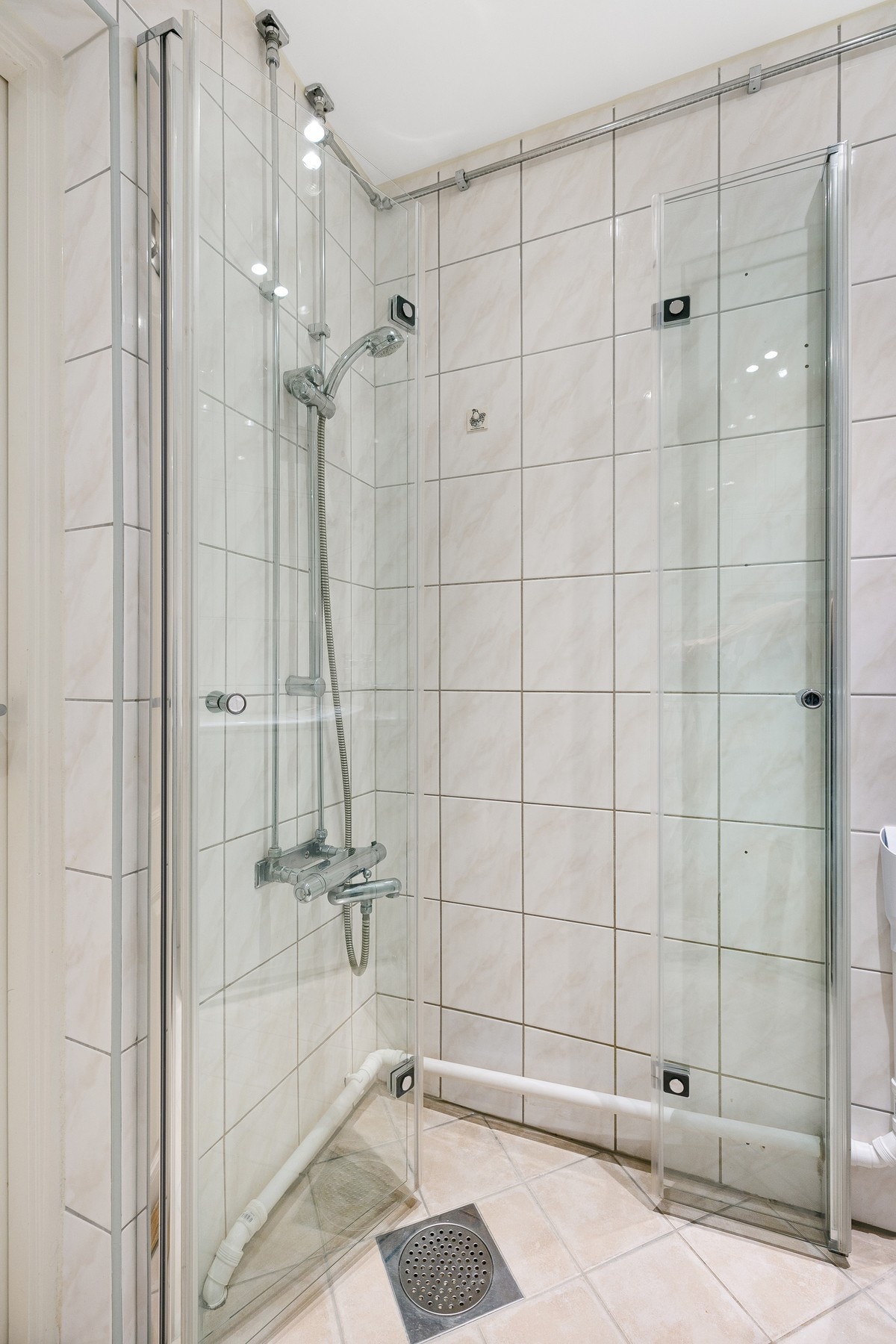 Innredningen på badet består av dussjone med innfellbare glassdører, vegghengt WC, servantskap, speil på vegg og opplegg for vaskemaskin. Galleribilde