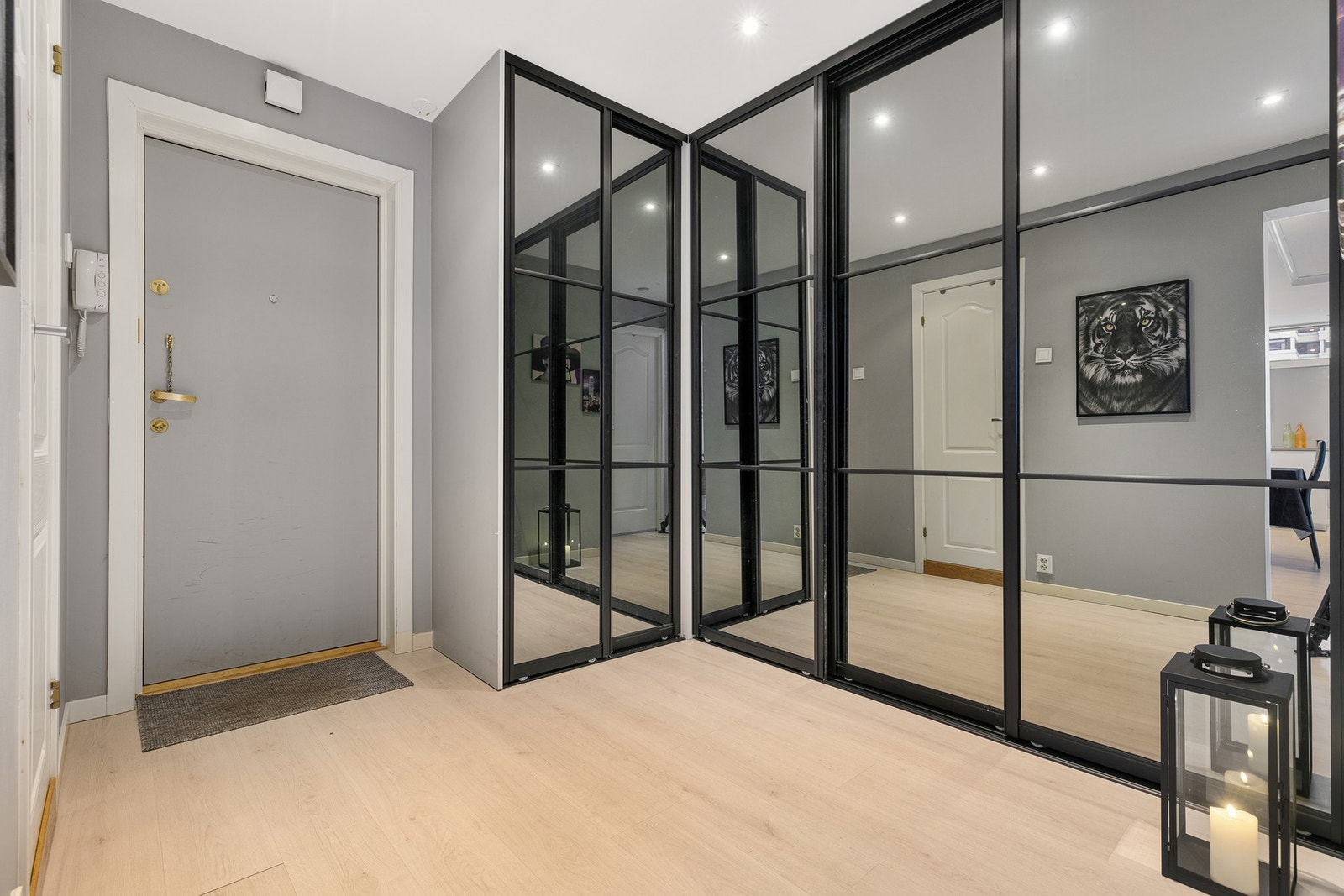 Velkommen inn i en romslig og stilfull entré med grå vegger og moderne laminatgulv. Galleribilde