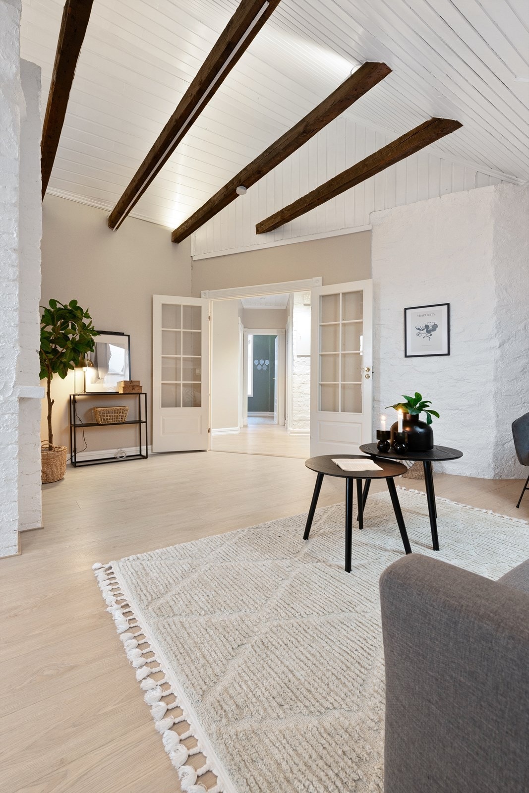 Lys stue med malte takbjelker. Galleribilde