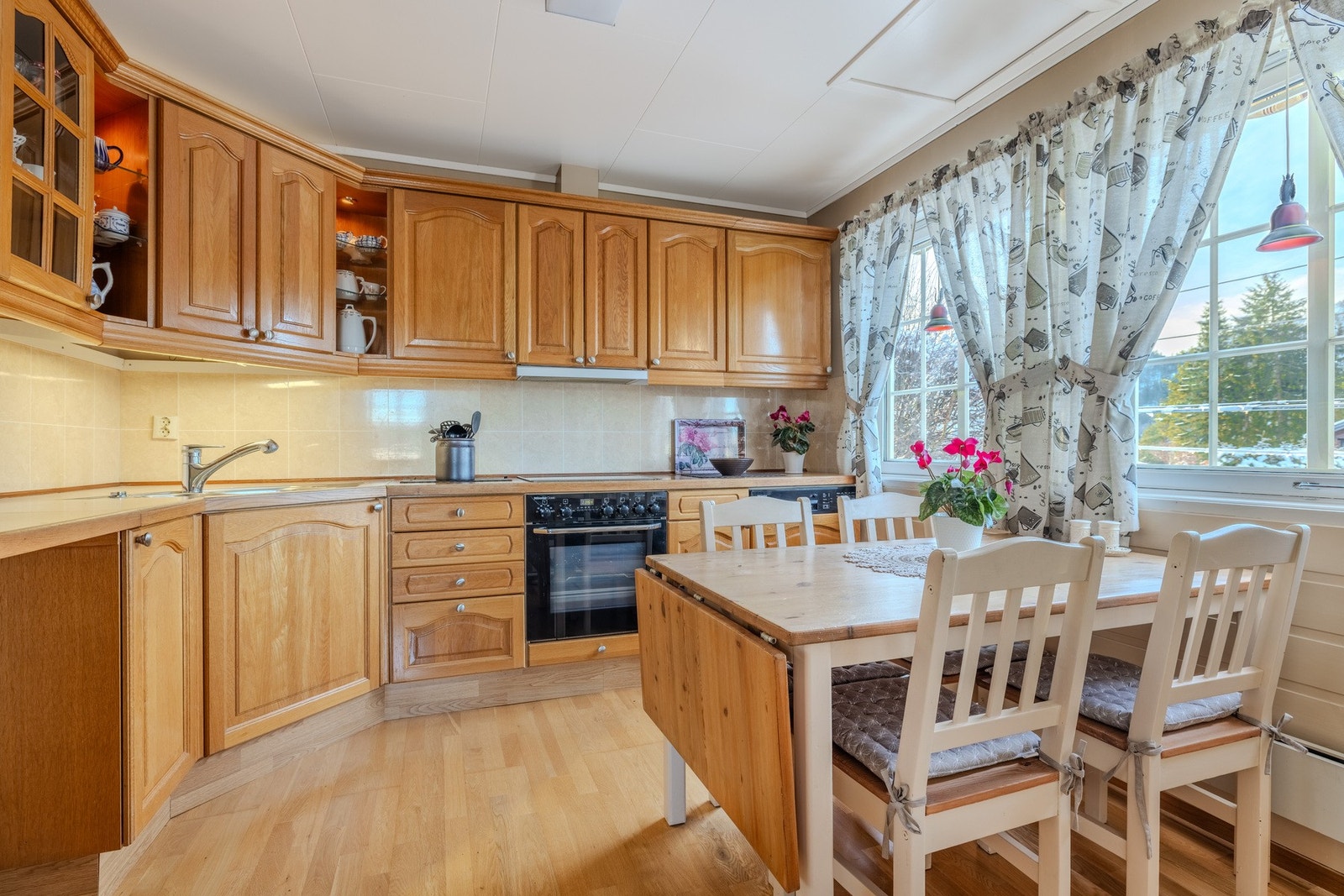 Koselig kjøkken med plass til bord ved kjøkkenvinduet. Galleribilde