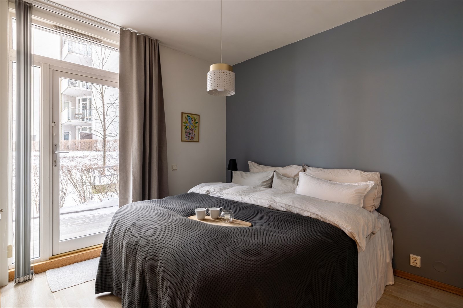 Et romslig og lunt hovedsoverom med kontrastvegg i blå som skaper en harmonisk atmosfære. Galleribilde