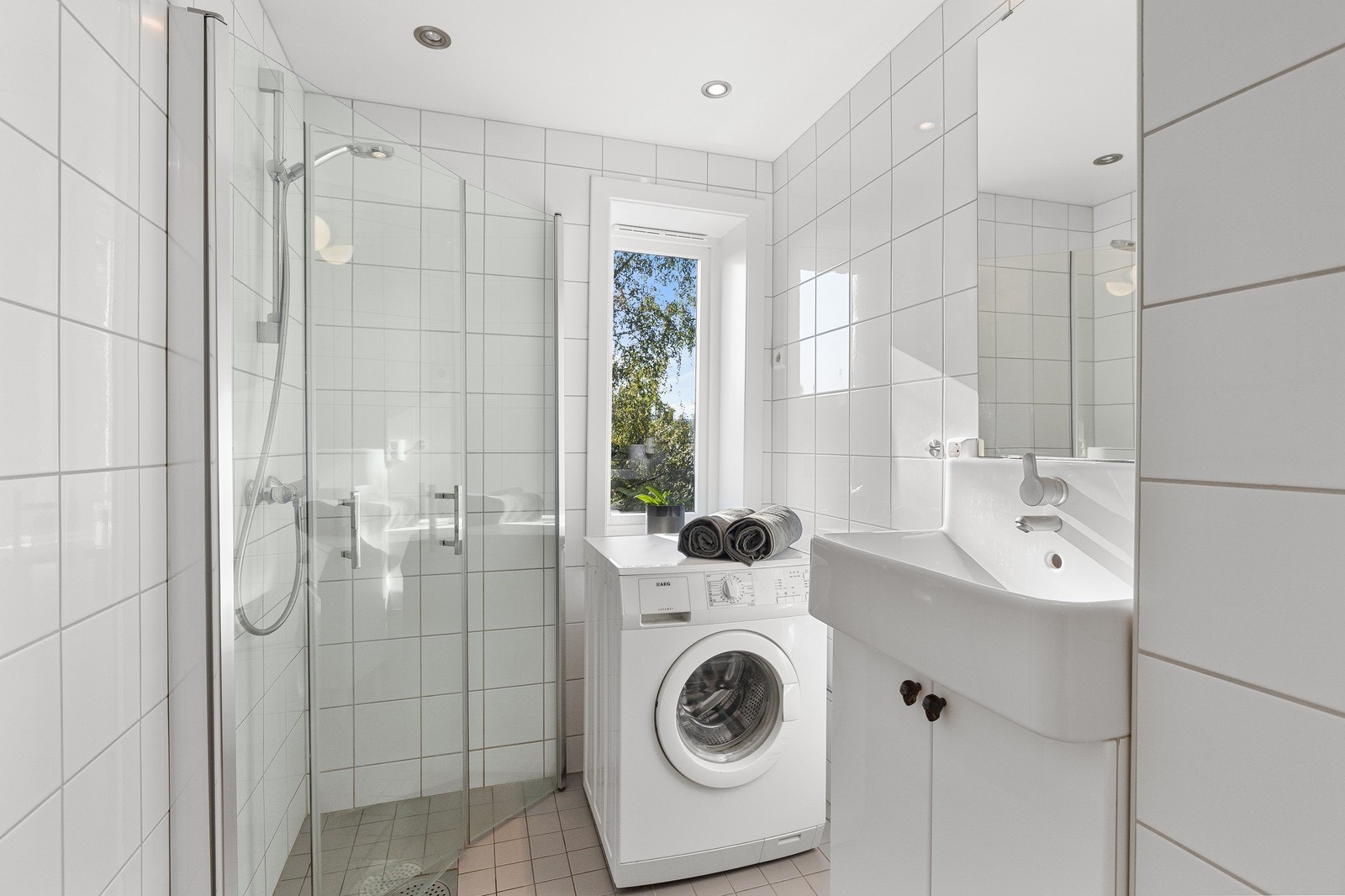 Badet er utstyrt med dusjhjørne med innfellbare dusjdører og blandebatteri fra Hansgrohe. Galleribilde