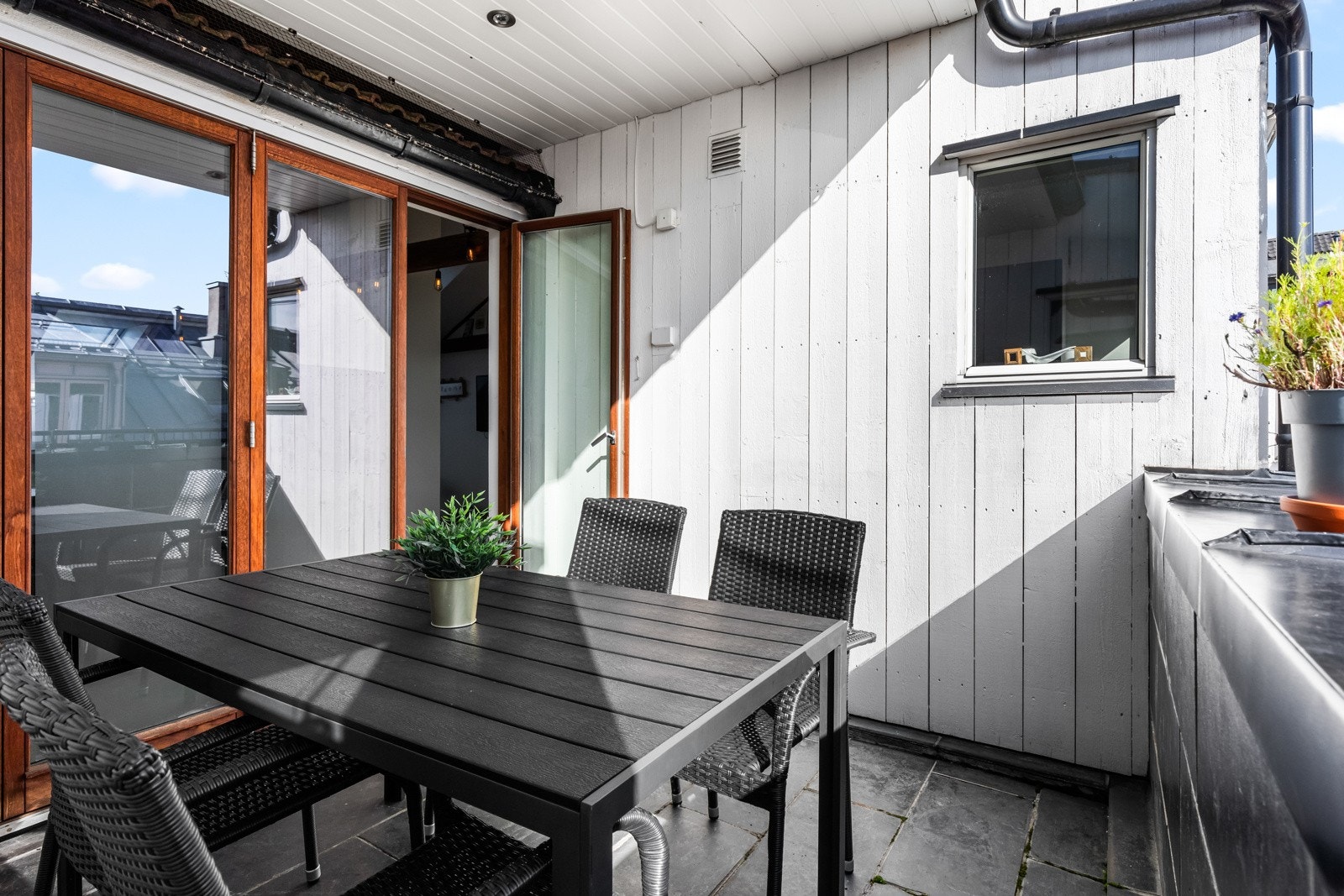 Terrassen er overbygget med utebelysning og stikkontakt på vegg. Galleribilde