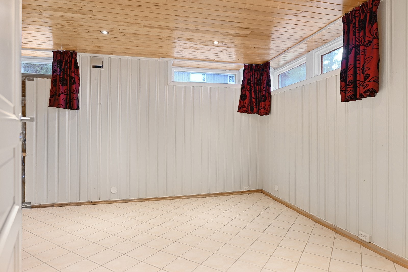 Innredet rom i underetasjen. Det er synlig fjell bak deler av kjellerveggene. Galleribilde