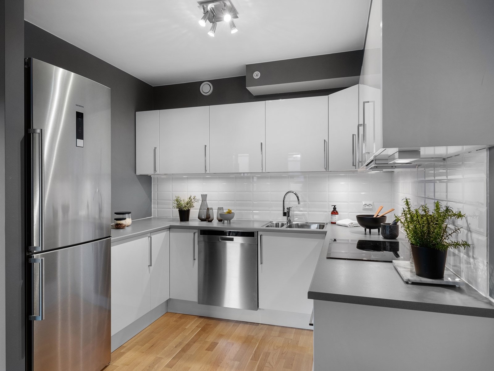 Praktisk løsning med spotter under overskap og god oppbevaring. Stilrent og tidløst. Fint tilbaketrukket fra stuen, men likevel i åpen løsning. Galleribilde