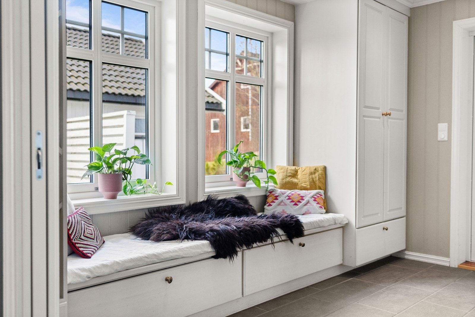 Videre har rommet downlights i hvitmalt himling, beigmalte panelplater på veggene og mørkegrå fliser. Galleribilde