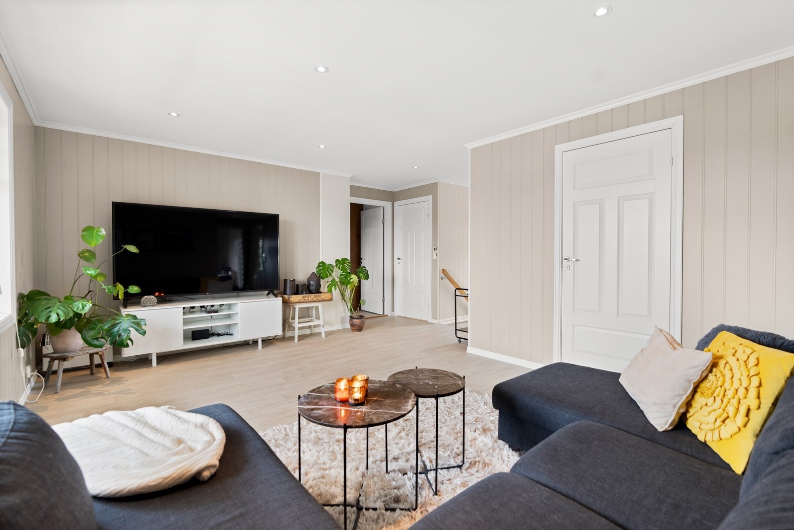 Rommet har hvittet laminatgulv, beigemalte panelplater på veggene og downlights i hvitmalt himling. To smale vinduer og en glassdør vender ut mot den overbygde verandaen. Galleribilde