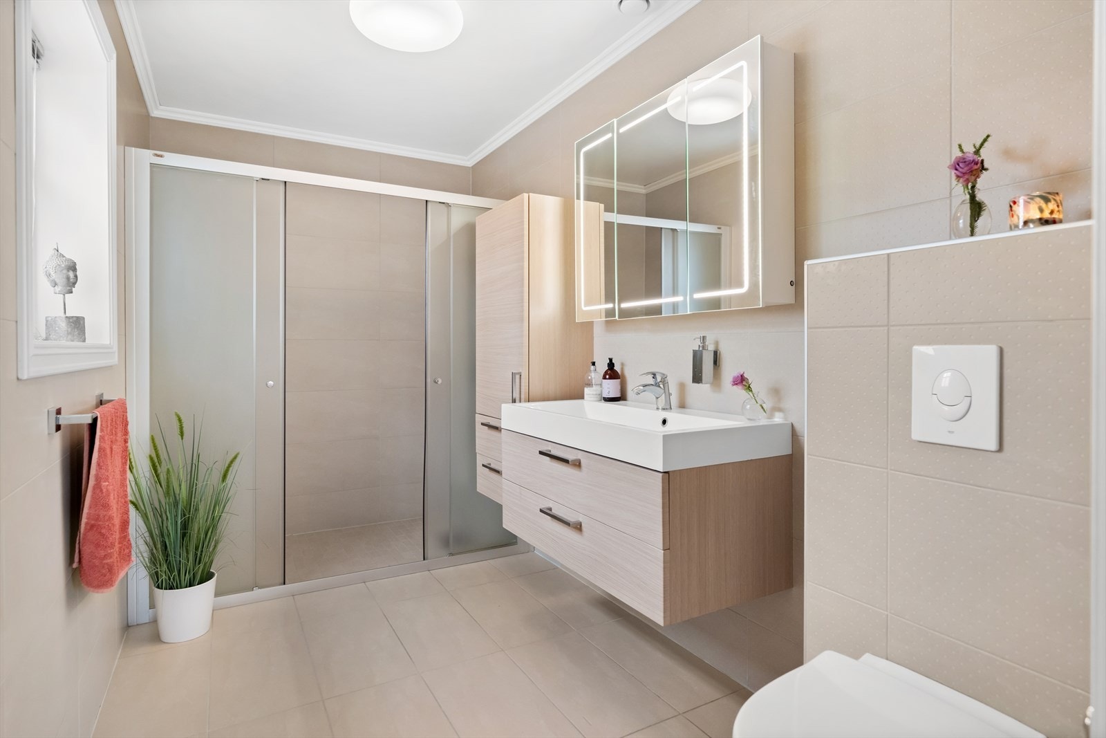 Badet i første etasje har en romslig dusjnisje med frostede vegger og skyvedører i glass. Galleribilde