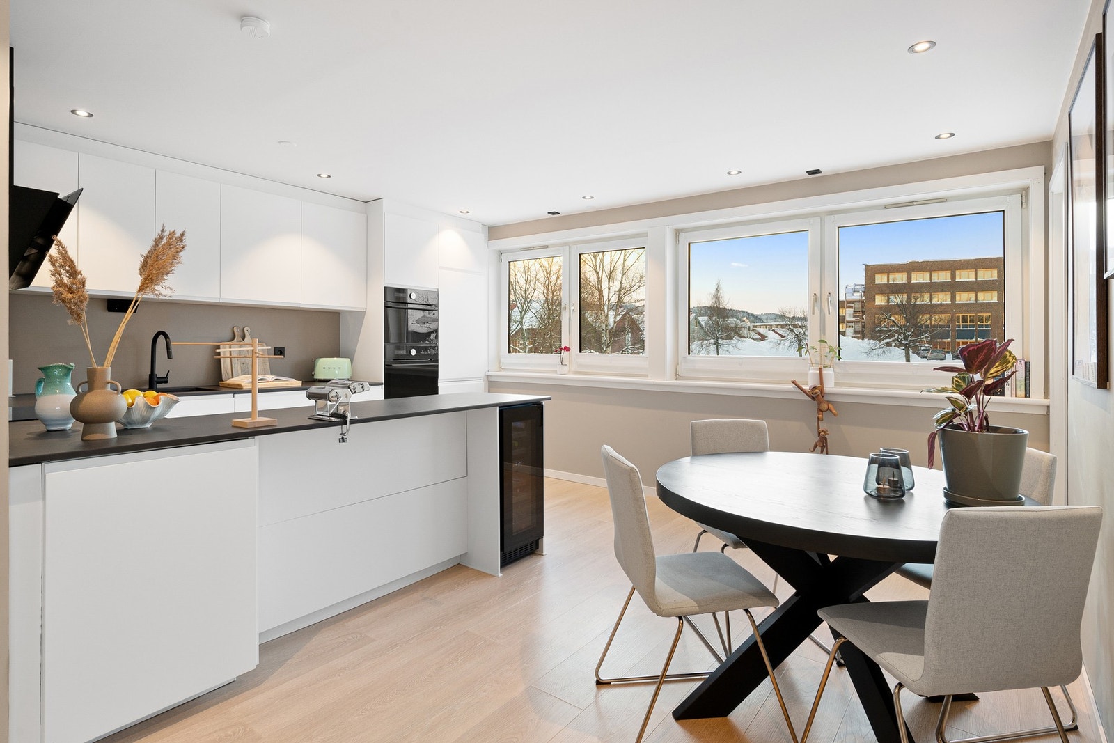 Hvitt, stilrent kjøkken med integrerte hvitevarer. Galleribilde