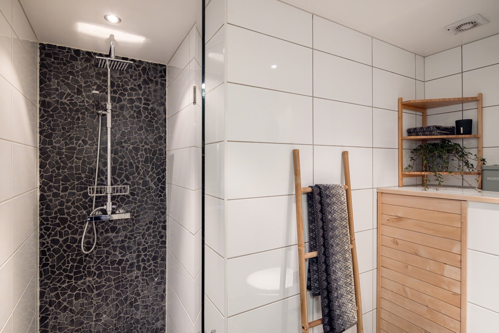 Badet er innredet med servantskap med høyglansfronter og heldekkende servant, speilskap med integrert belysning, dusjnisje og vegghengt toalett. Galleribilde
