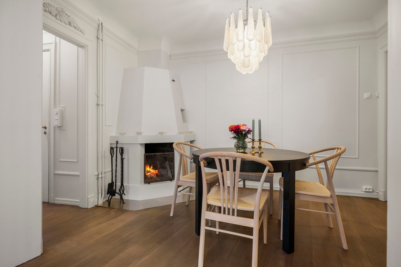 Den store og åpne hjørnepeisen gjør spisestuen til leilighetens hjerte og sosiale samlingspunkt Galleribilde