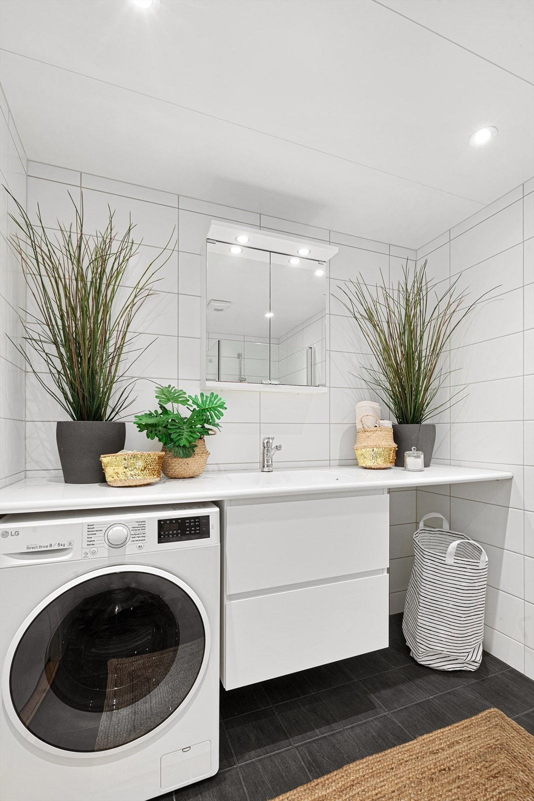 Dusjbad/wc med heldekkende servant, underskap og overskap med speil og belysning. Downlights i himlingen. Galleribilde