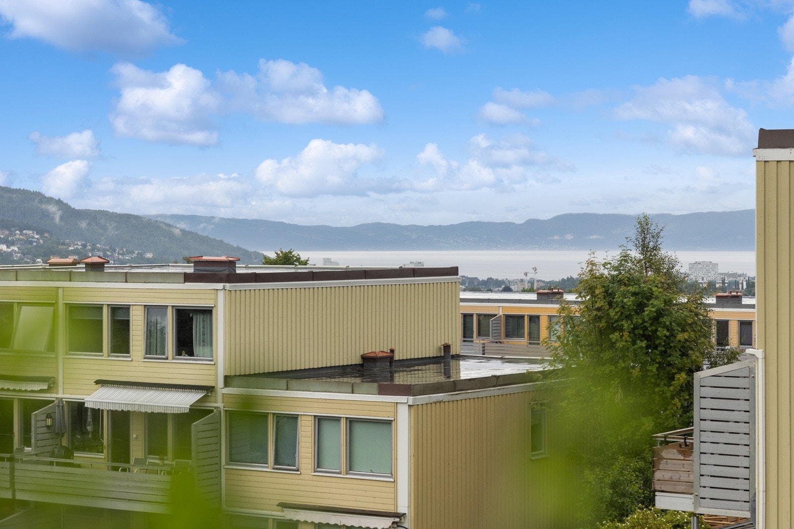 Fra soveromsvinduet nyter man nydelig utsikt ned mot sentrum, Trondheimsfjorden og Fosenalpene. Sommerbilde fra 2022. Galleribilde