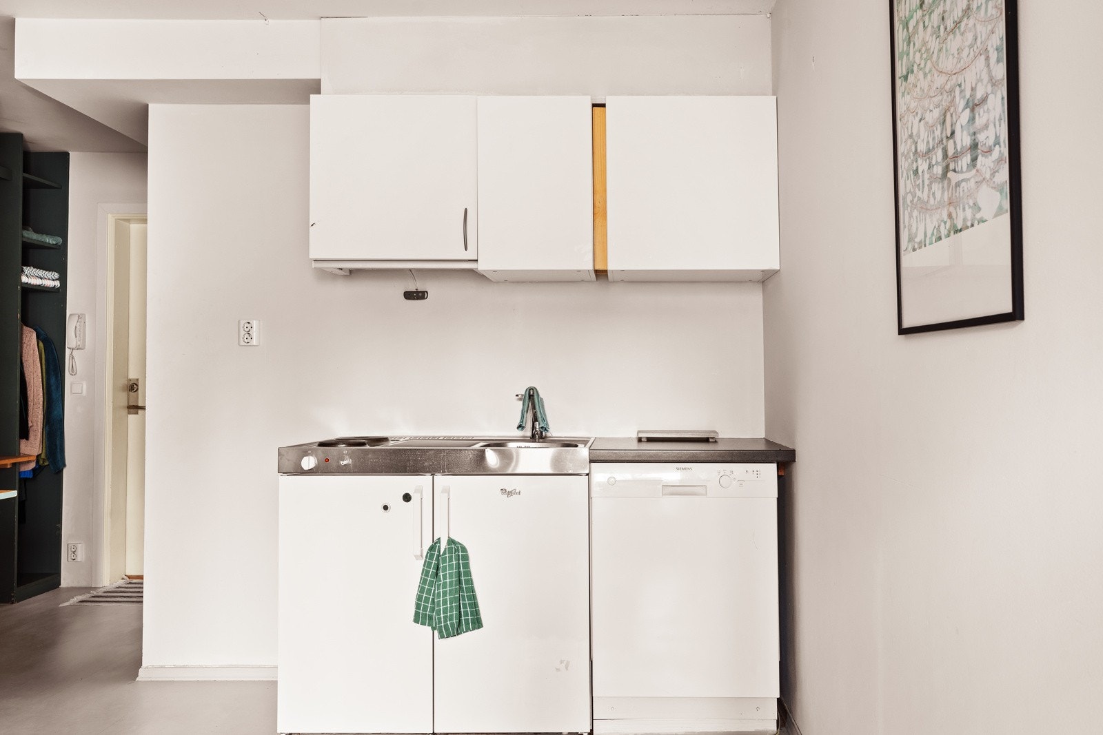 Praktisk hybelkjøkken med oppvaskkum, stål benkebeslag, 2 stk. kokeplater og integrert kjøleskap. Det er opplegg for oppvaskmaskin. Galleribilde