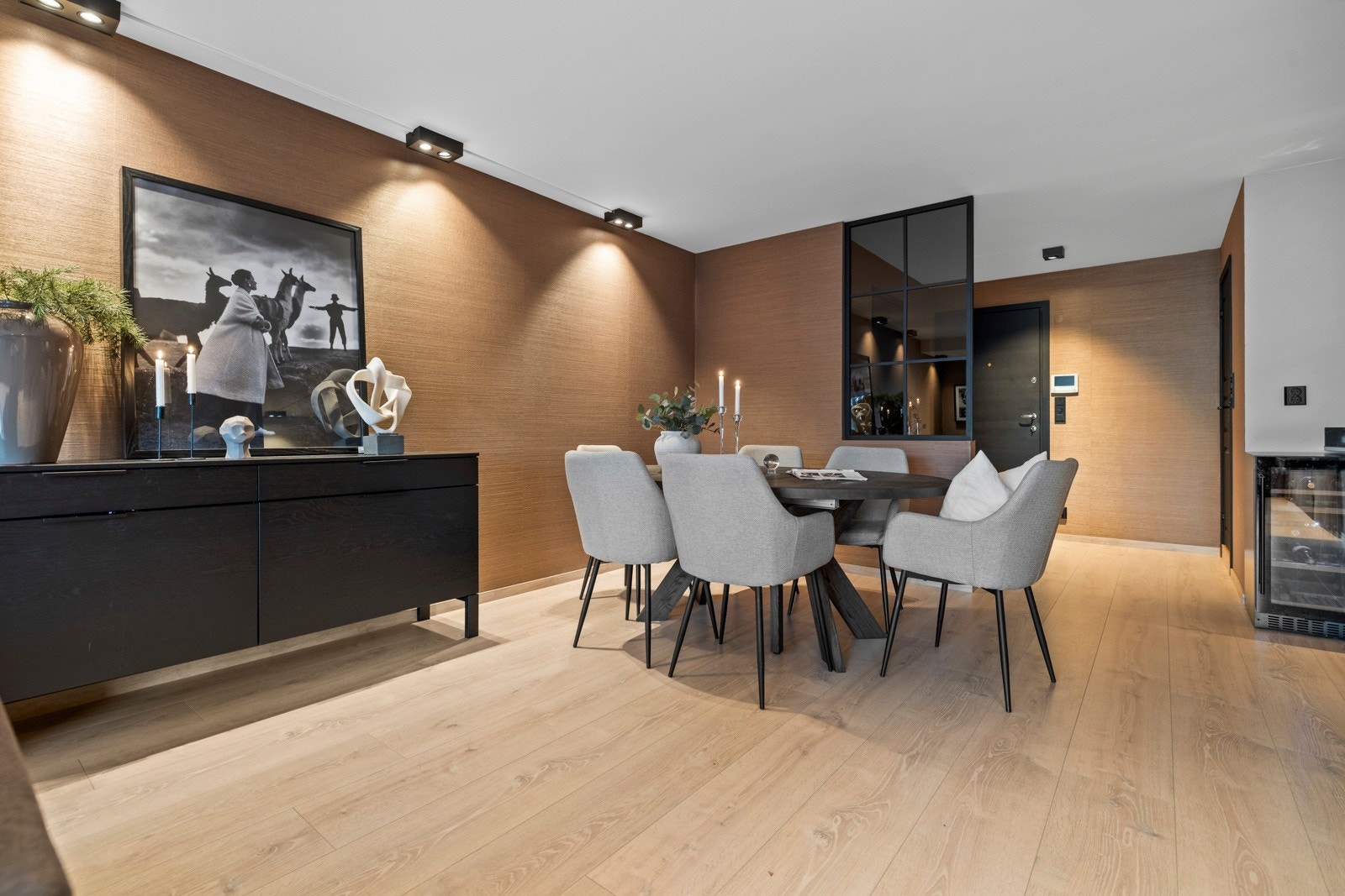 Industriveggen som skiller spisestuen og inningangspartiet gir hjemmet et moderne og stilrent design. Galleribilde