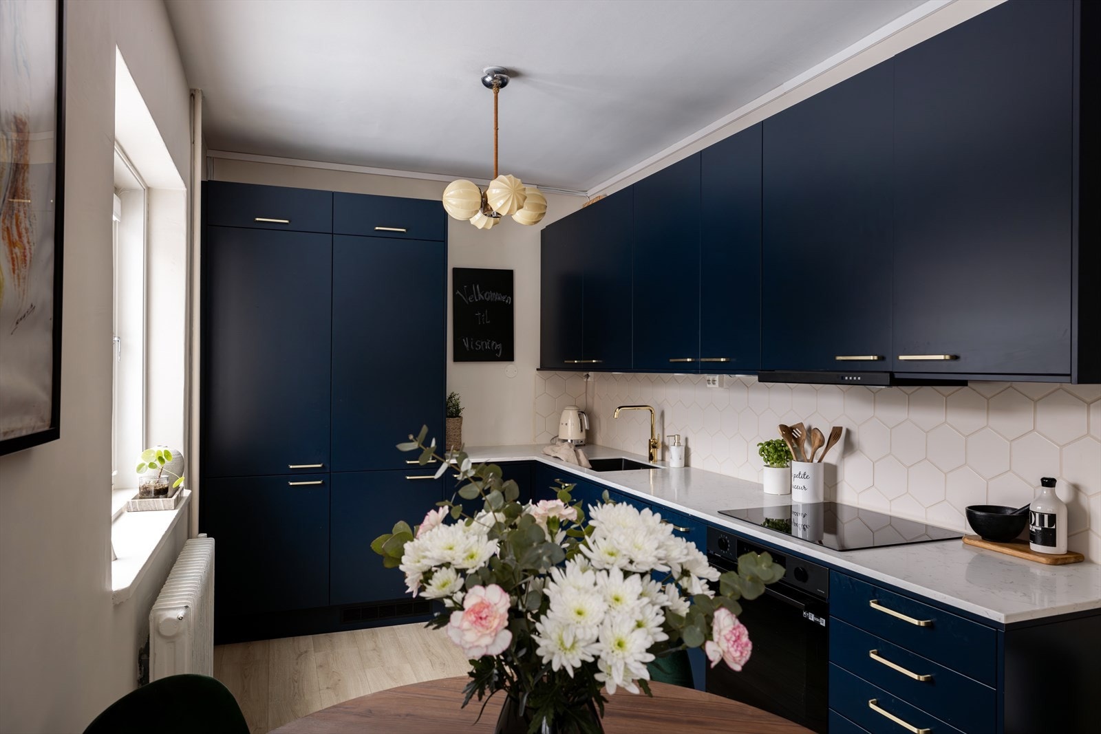 Integrerte hvitevarer fra Bosch inkluderer en induksjonstopp, stekeovn, kjøl/fryseskap og en oppvaskmaskin under benkeplate. Galleribilde