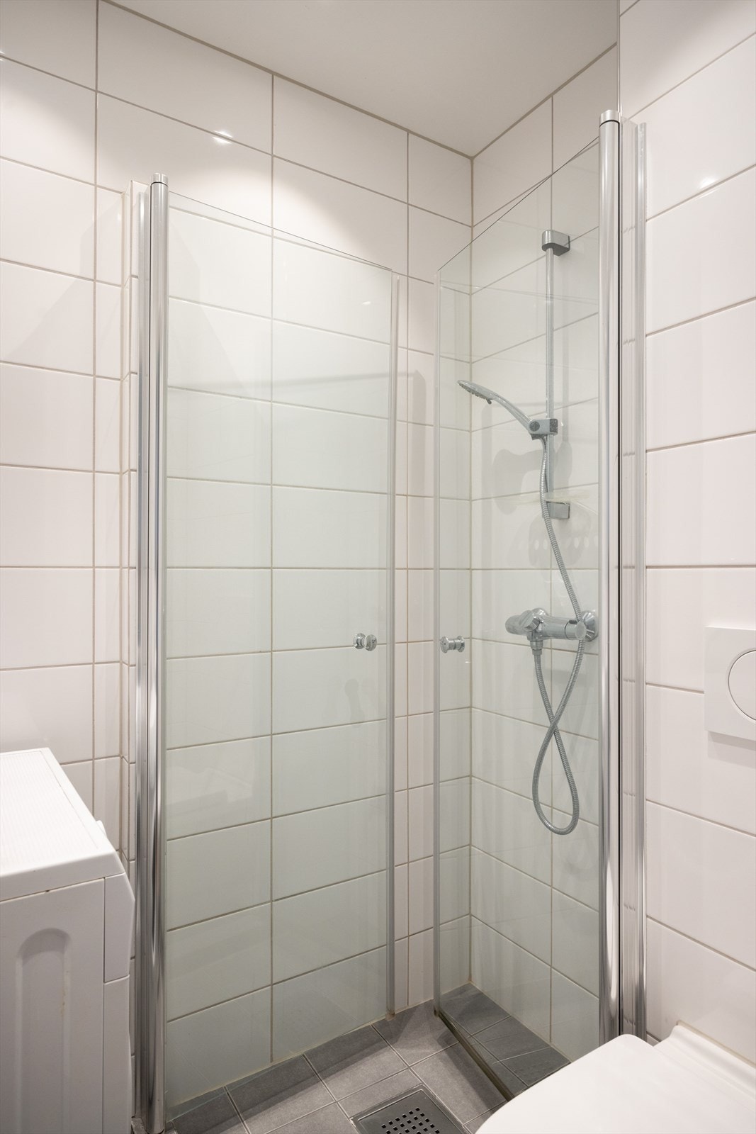 - Baderommet er innredet med vegghengt klosett, servant med innredning og dusjhjørne med svingbare glassdører. Opplag for vaskemaskin. Naturlig avtrekk - Galleribilde