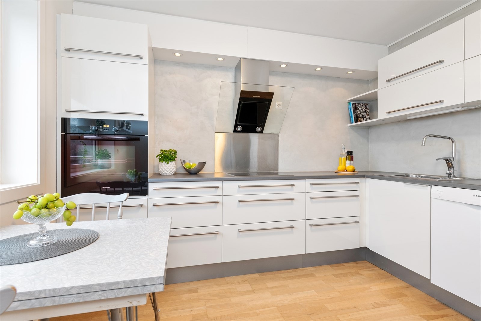 Lyst og tidløst kjøkken med integrerte hvitevarer, god benkeplass og stilren design Galleribilde