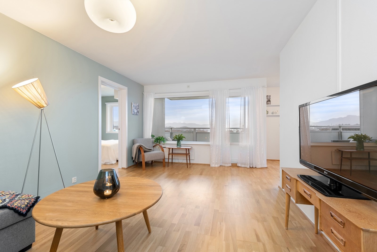 Lys og innbydende stue med store vindusflater Galleribilde