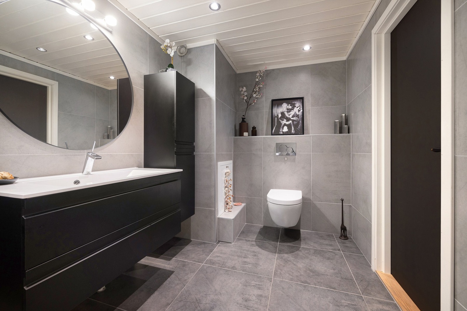 Badet er utstyrt med badekar, vegghengt toalett og opplegg for vaskemaskin, en god kombinasjon av komfort og funksjonalitet. Galleribilde