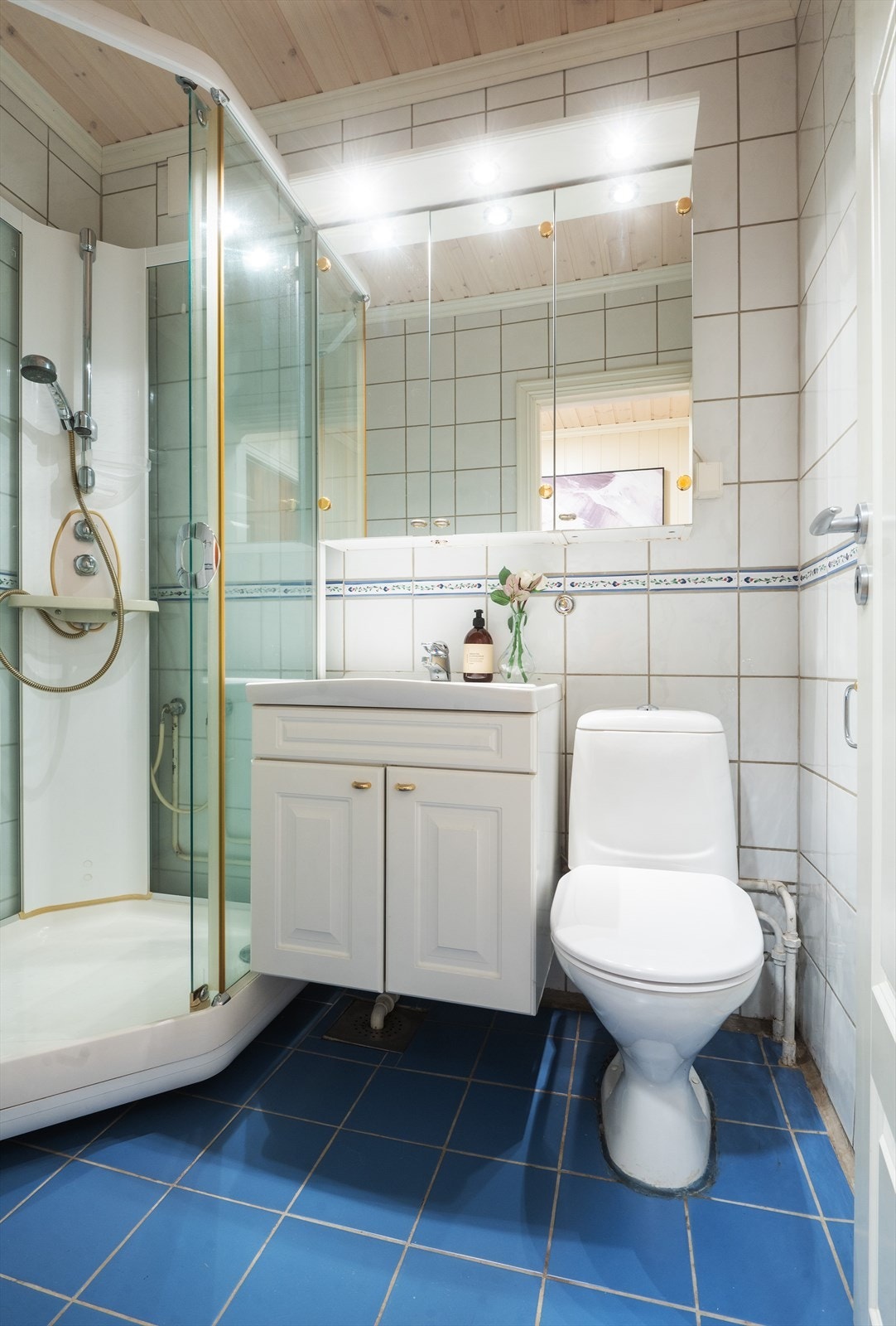 Innredning bestående av klosett, servantinnredning, servant med ettgreps blandebatteri, speil med lysarmatur og dusjkabinett. Nytt klosett i 2024. Galleribilde