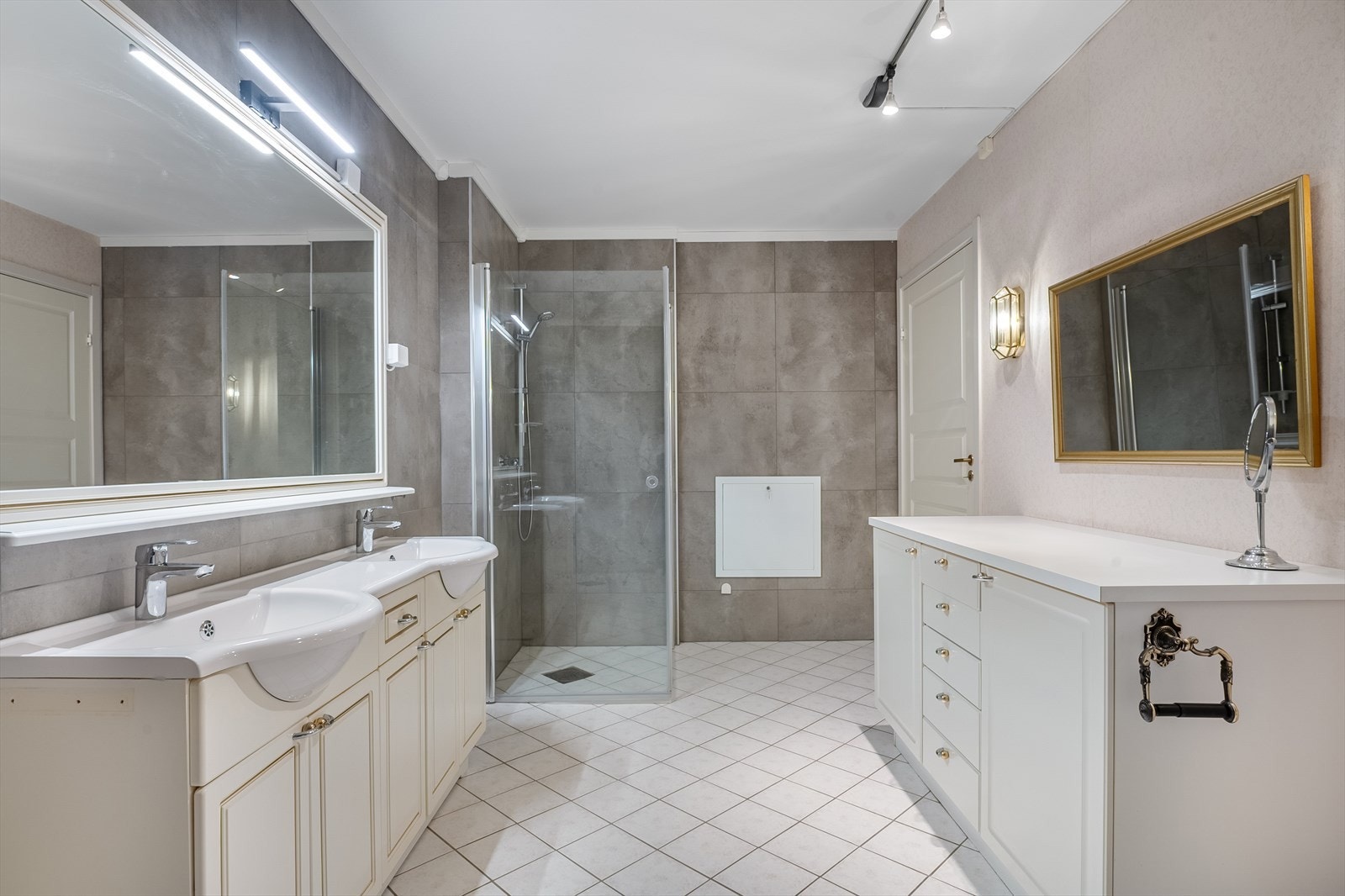 Badet har meget god størrelse, gulvvarme og overflater i en kombinasjon av fliser og våtromstapet. Tre av veggene fikk nye fliser i 2024. Galleribilde