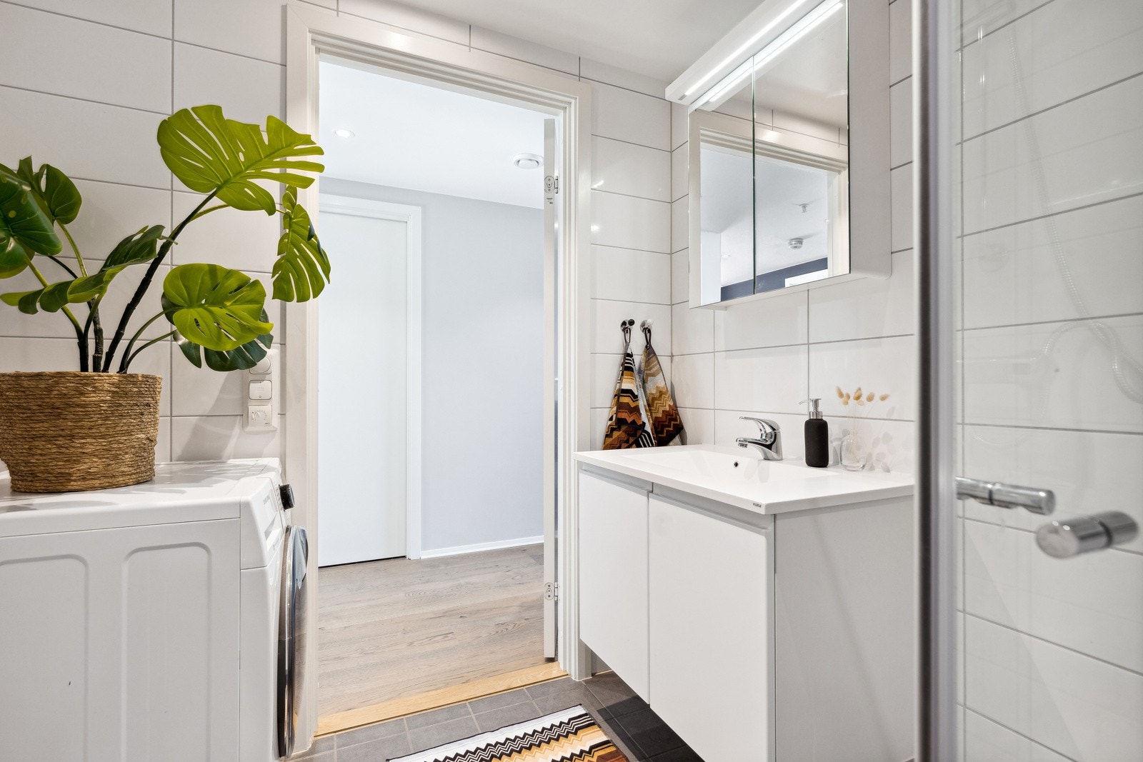 Av innredning har badet moderne baderomsmøbler, opplegg for vaskemaskin, innfellbart dusjhjørne og vegghengt toalett med spylefunksjon. Galleribilde