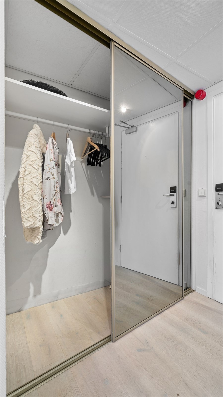 Innbydende entré med stor skyvedørsgarderobe Galleribilde