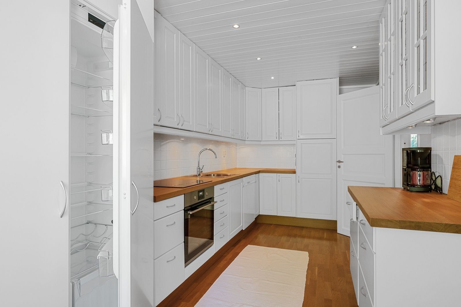 Kjøkkenet har integrerte hvitevarer og heltre benkeplate Galleribilde