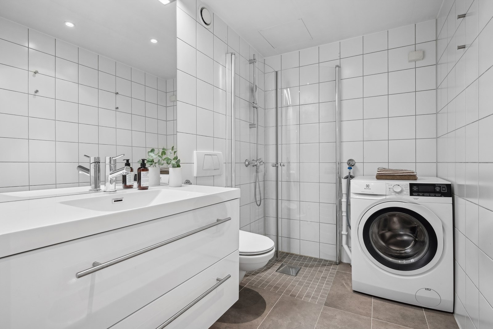 Flislagt bad med gulvvarme og opplegg for vaskemaskin Galleribilde