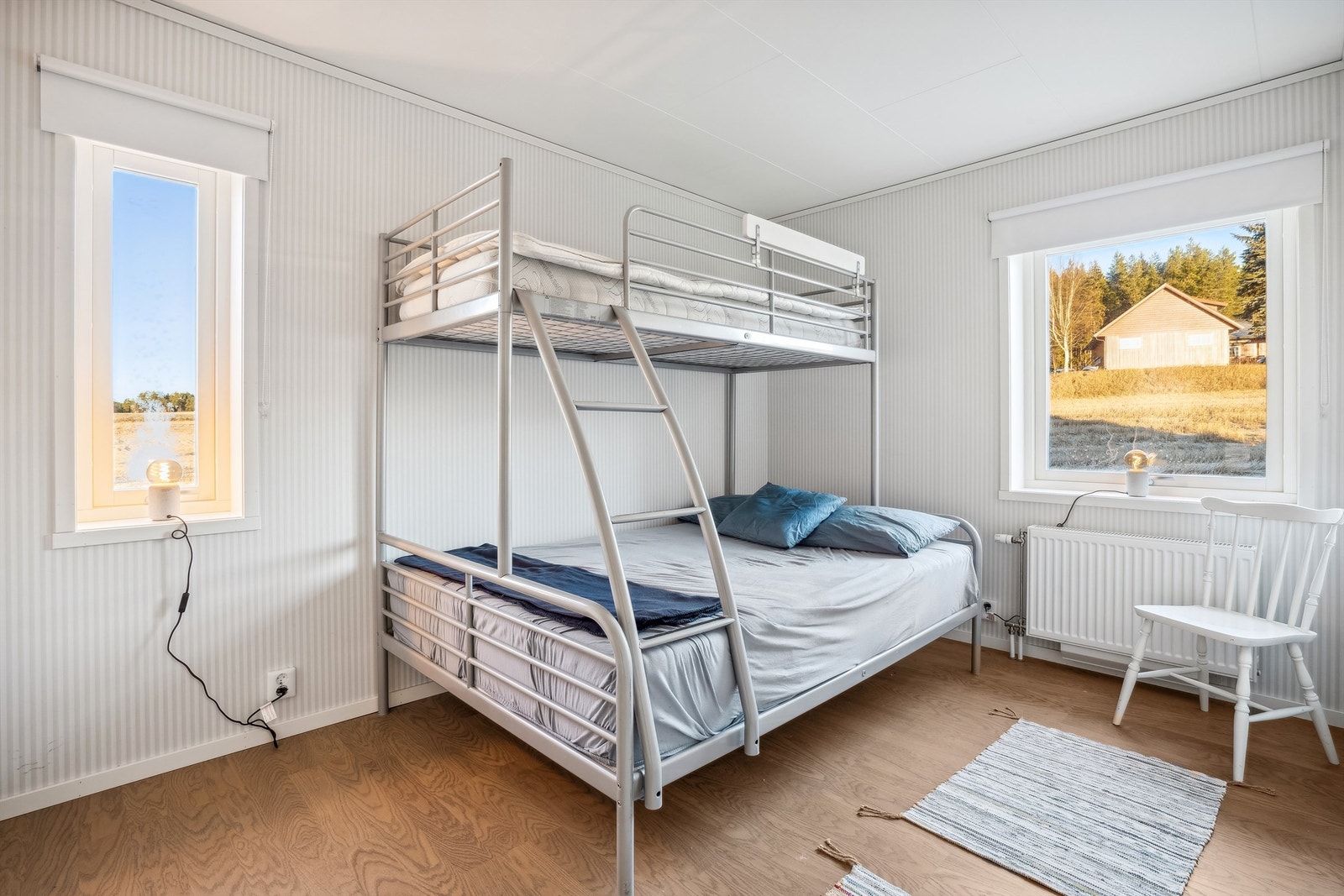 Det andre soverommet har stripete lys tapet på veggene og laminat på gulvet. Rommet er romslig med garderobeskap etablert i enden av rommet. Galleribilde