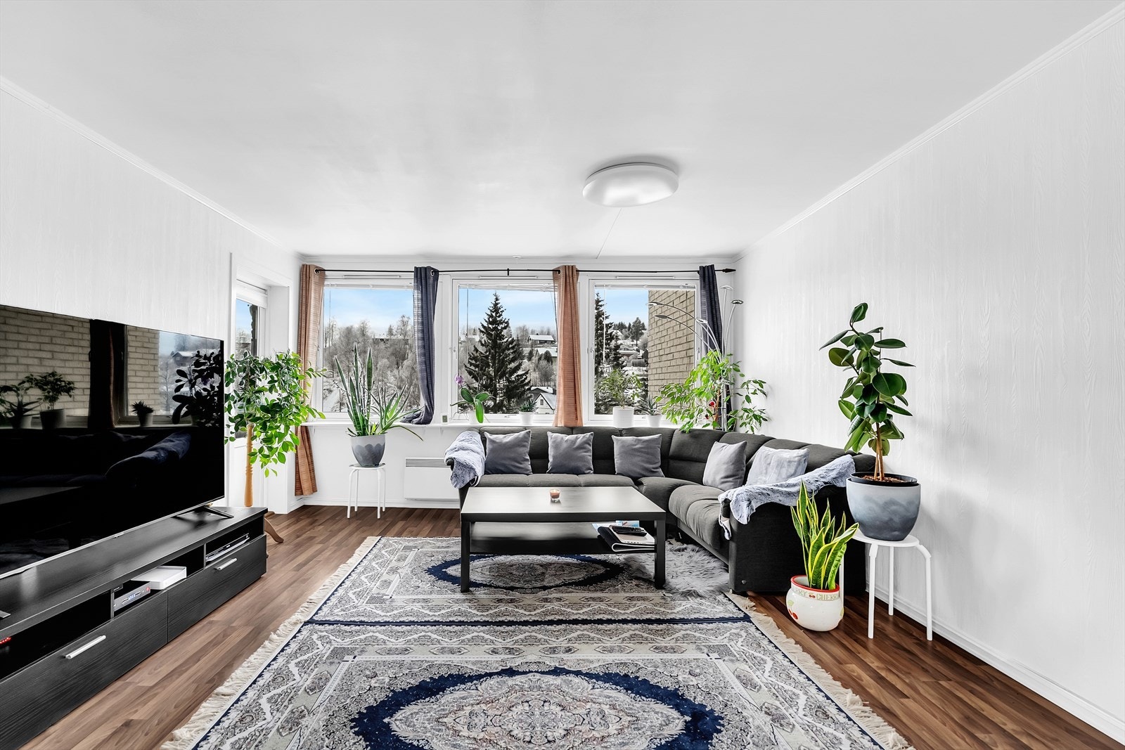 Stuen er lys og luftig med lysmalte overflater og store vinduer som slipper inn rikelig med lys. Galleribilde