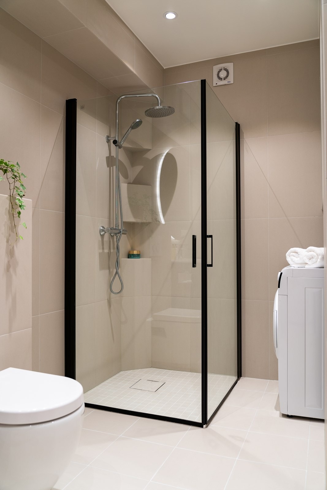 Badet er gjennomført med sorte detaljer, rundt speil med integrert belysning og regnfallsdusj, noe som gir en spa-følelse. Galleribilde