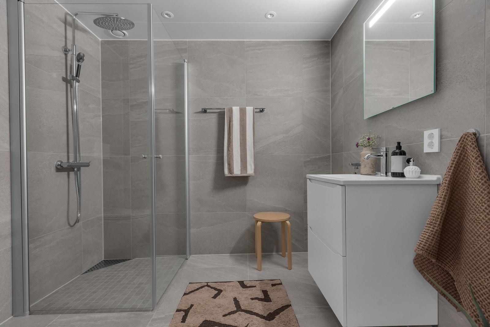 Flislagt på både gulv og vegger. Innfellbare glassdører i dusjsonen. Innredning med heldekkende servant Galleribilde