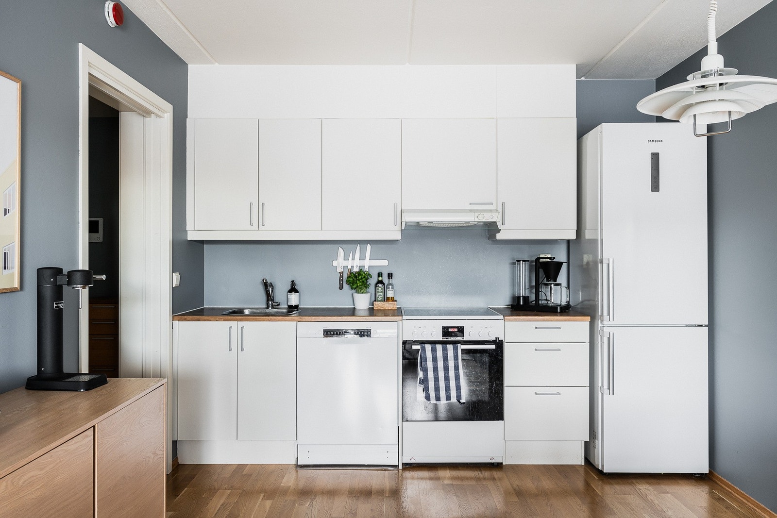 Kjøkkenet er plassert i åpen løsning med stuen, og er utstyrt med ventilator og opplegg for oppvaskmaskin. Galleribilde