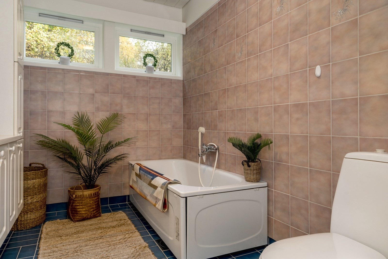 Flislagt bad innredet med baderomsinnredning med nedfelt vask, badekar og toalett. Galleribilde